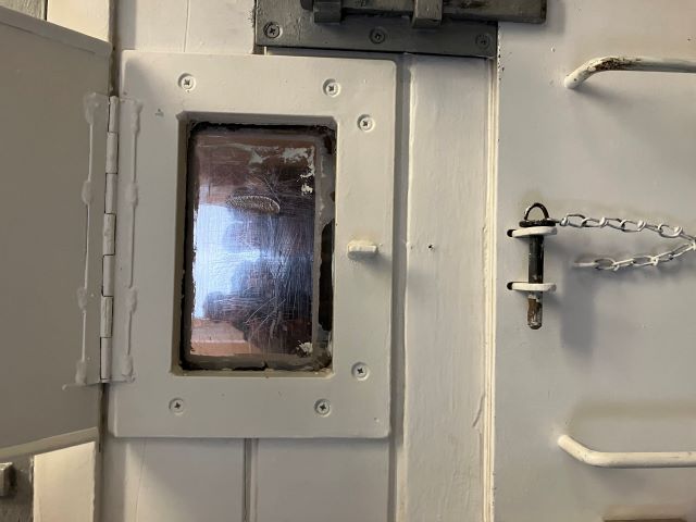 Blick von außen durch das kleine Guckfenster in eine Zelle